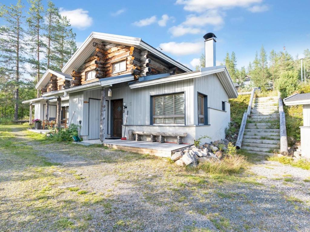 a log home with a porch and a house at Holiday Home Rukaköngäs 20 includes one ski lift tick by Interhome in Ruka