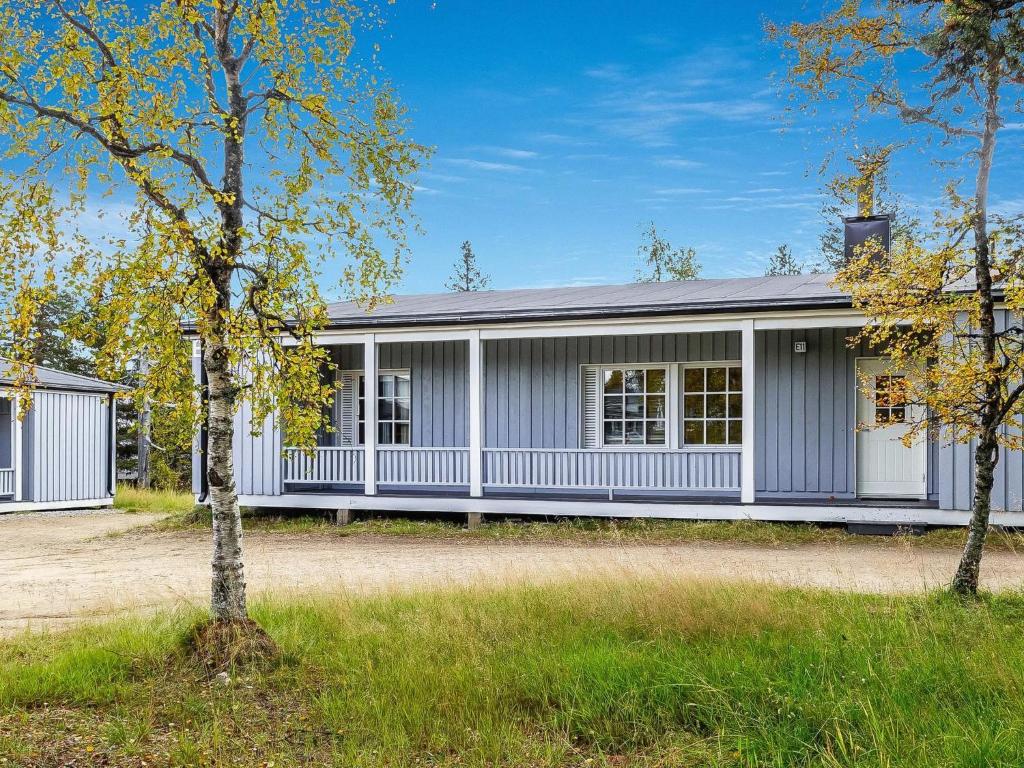 ein weißes Haus mit einem Baum davor in der Unterkunft Holiday Home Saariseläntie 8e11 by Interhome in Saariselkä