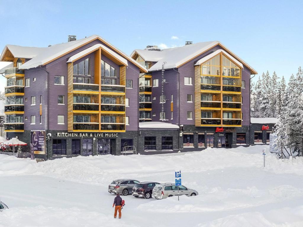 a man standing in the snow in front of a building at Holiday Home Levin kunkku b5 by Interhome in Sirkka