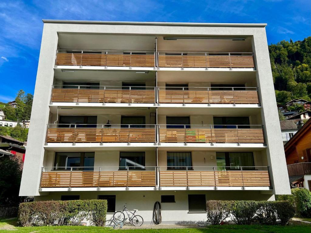 un immeuble d'appartements avec balcon et terrasse en bois dans l'établissement Apartment Alte Gasse 9 by Interhome, à Engelberg