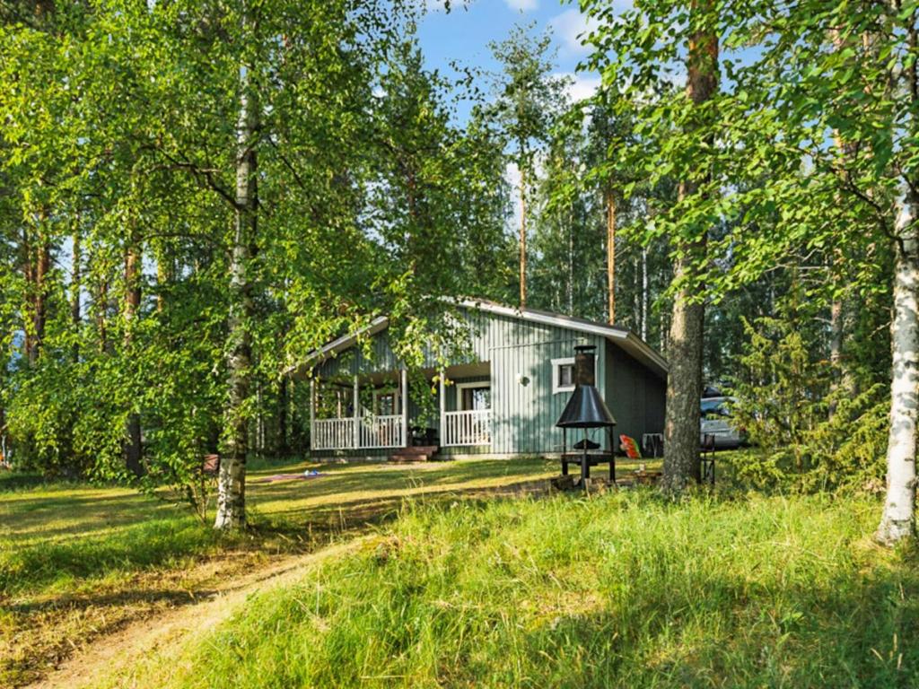 ein Cottage im Wald mit einem Weg dorthin in der Unterkunft Holiday Home Hauki by Interhome in Hiukkajoki