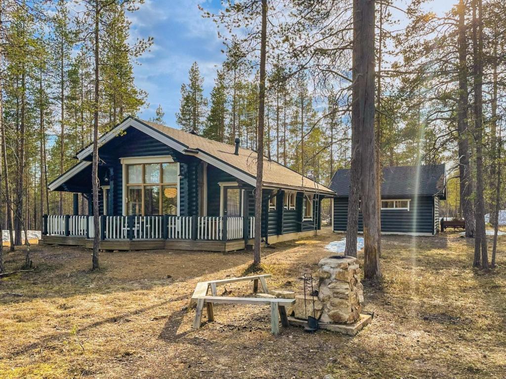 a cabin in the woods with a bench in front of it at Holiday Home Hirsikoto by Interhome in Saariselka