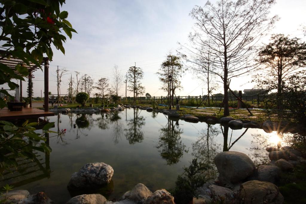 a pond with trees and rocks in a park at Sweet Heart B&amp;B in Ji&#39;an