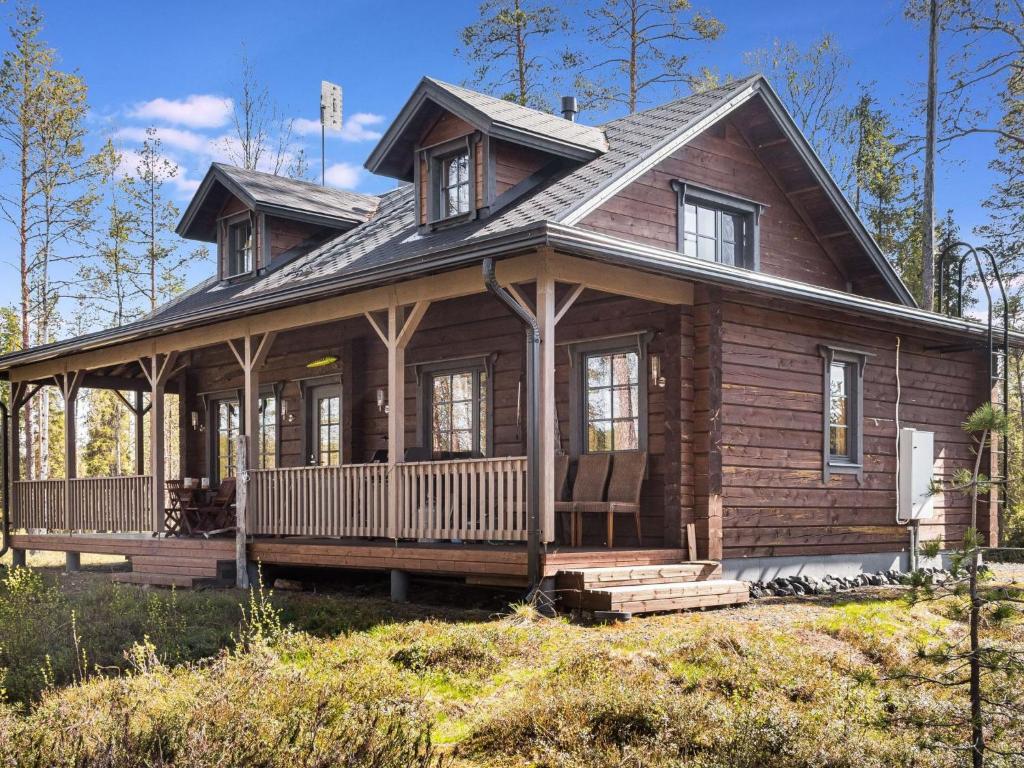 a log cabin with a porch and a house at Holiday Home Kiehtäjän virta by Interhome in Käylä