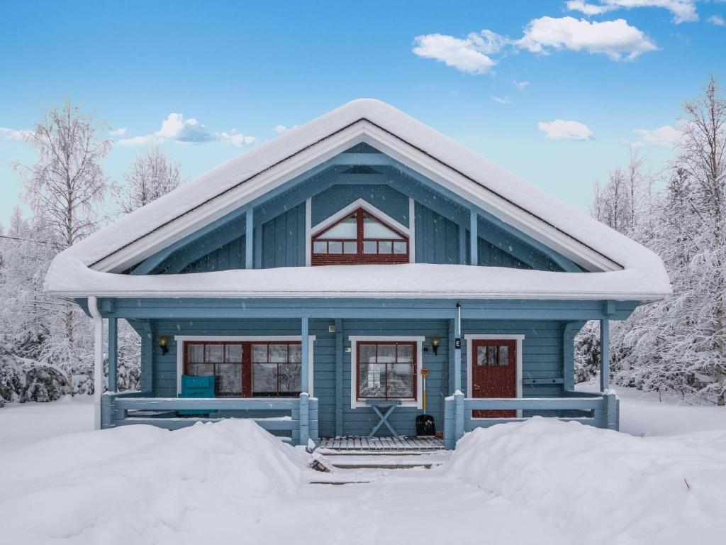 ein blaues Haus mit Schnee auf dem Dach in der Unterkunft Holiday Home Lehtotuvat e by Interhome in Kotila