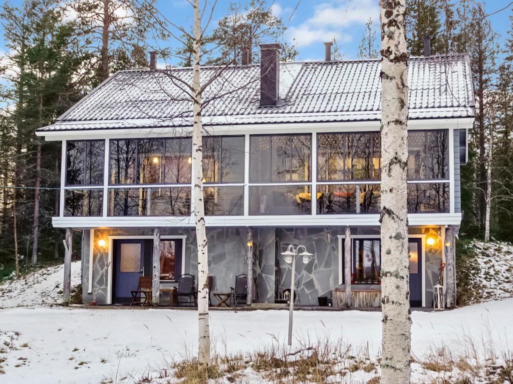 a house with large windows in the snow at Holiday Home Äkäsjärven lomamökit 2 by Interhome in Muonio