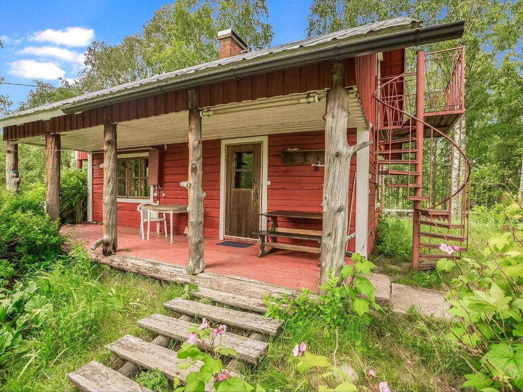 ein Holzhaus mit einem Tisch auf einer Terrasse in der Unterkunft Holiday Home Kesämäki by Interhome in Hiukkajoki
