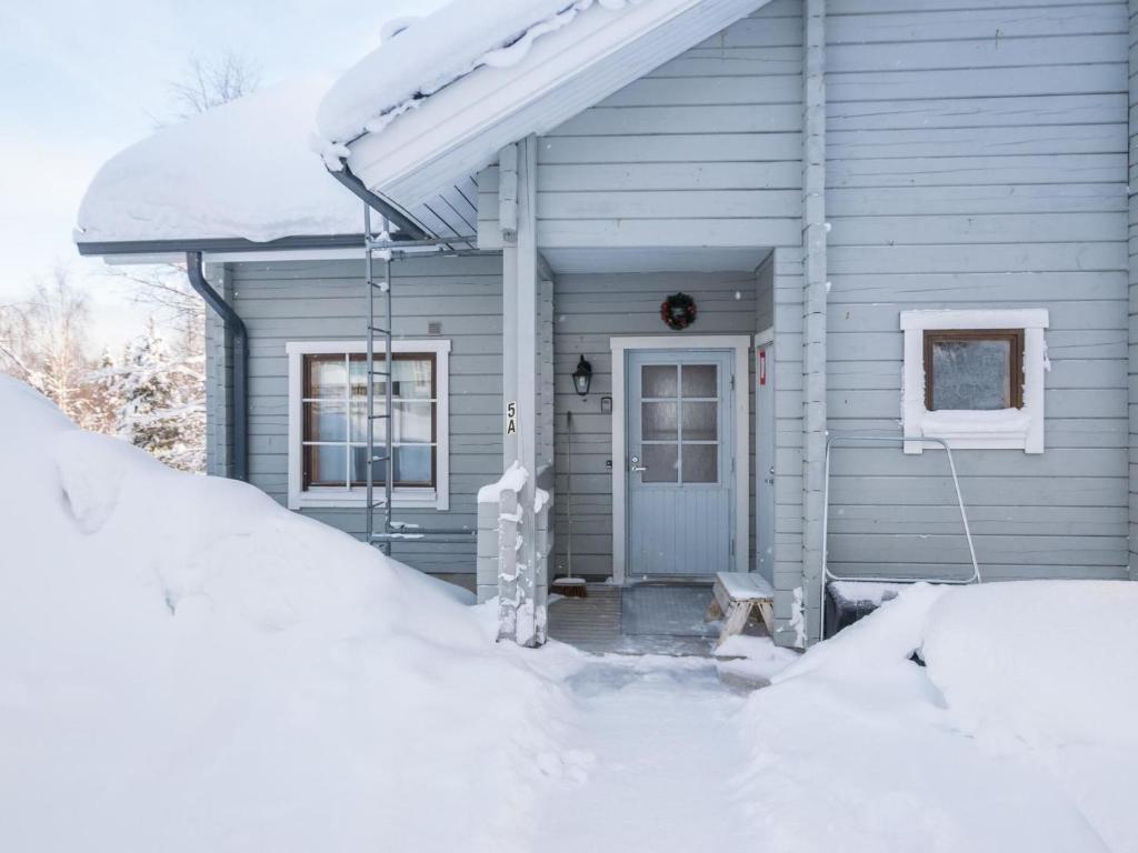 une maison couverte de neige avec une terrasse couverte dans l'établissement Holiday Home Lomaluola 5a paritalo by Interhome, à Hyrynsalmi