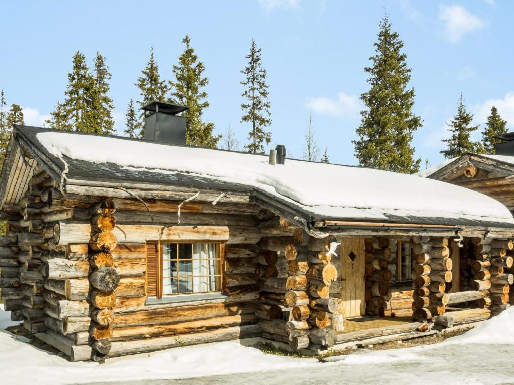 Cabaña de madera con nieve en el techo en Holiday Home Luostonseita 1 by Interhome, en Luosto
