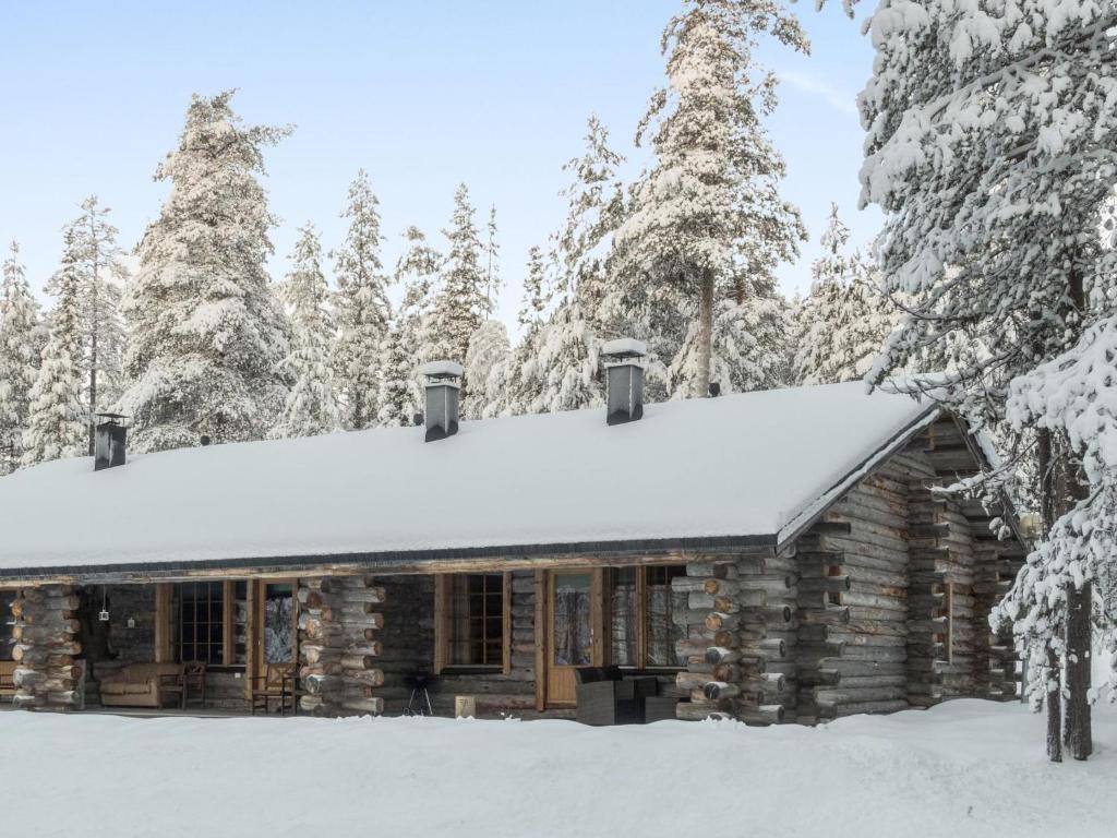 a log cabin with snow on the roof at Holiday Home Sallan savu a by Interhome in Salla
