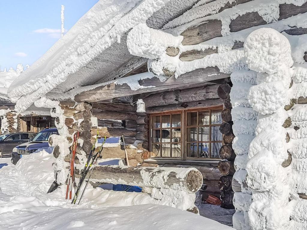ein schneebedecktes Gebäude mit Skiern außerhalb des Gebäudes in der Unterkunft Holiday Home Vilkkuna 20 a by Interhome in Syöte