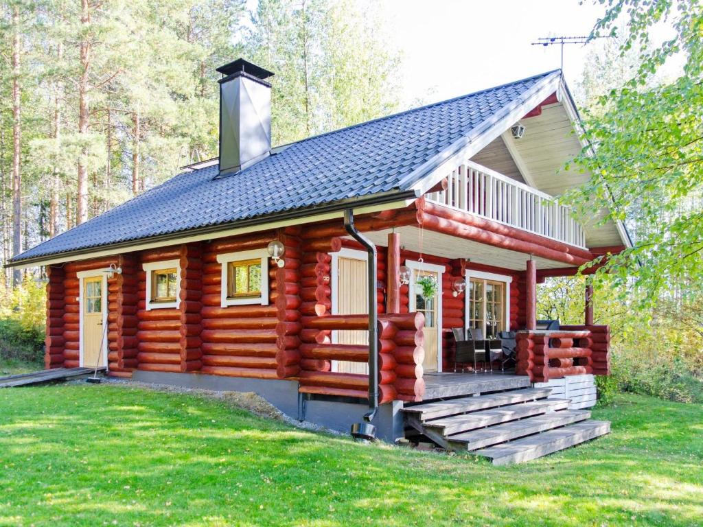 a log cabin in the woods with a porch at Holiday Home Suvituuli by Interhome in Liperi