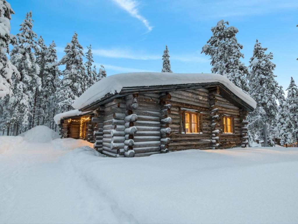 a log cabin with snow on the roof at Holiday Home Lumiankelo by Interhome in Sirkka