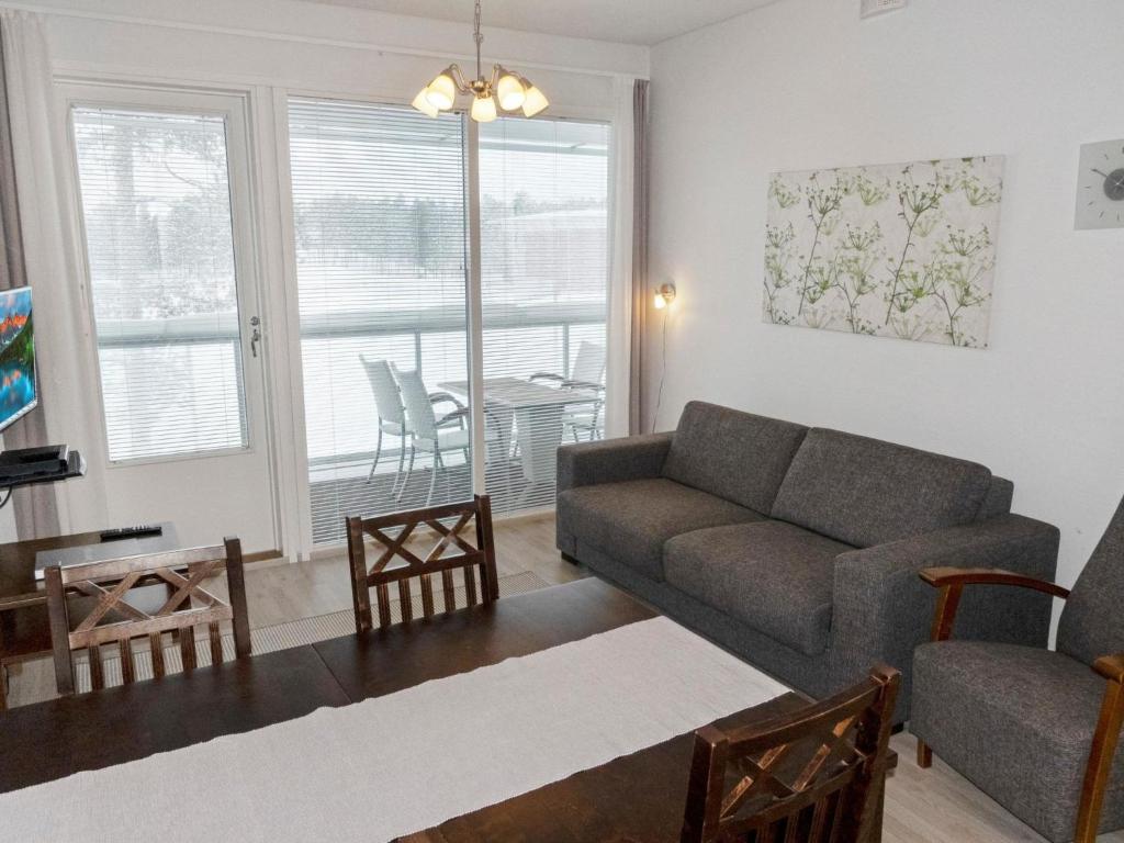 uma sala de estar com um sofá e uma mesa em Holiday Home Golfstar 402 by Interhome em Kiviniemi