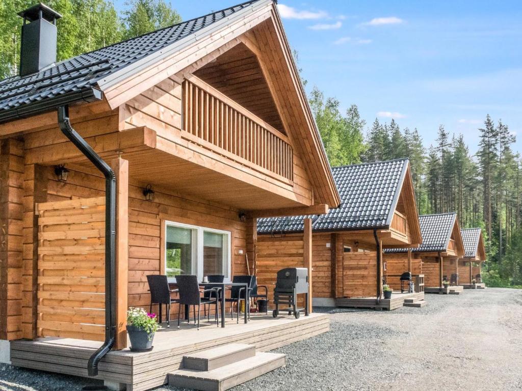 une cabane en rondins avec une terrasse et un coin repas dans l'établissement Holiday Home Kolin kangastus apila 1 by Interhome, à Kolinkylä