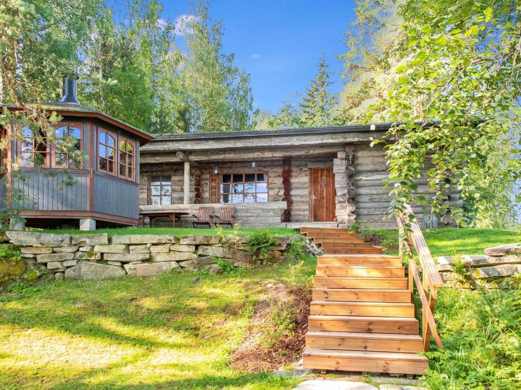 a log cabin with a staircase leading to the front of it at Holiday Home Kelosyväri 17 by Interhome in Nilsiä