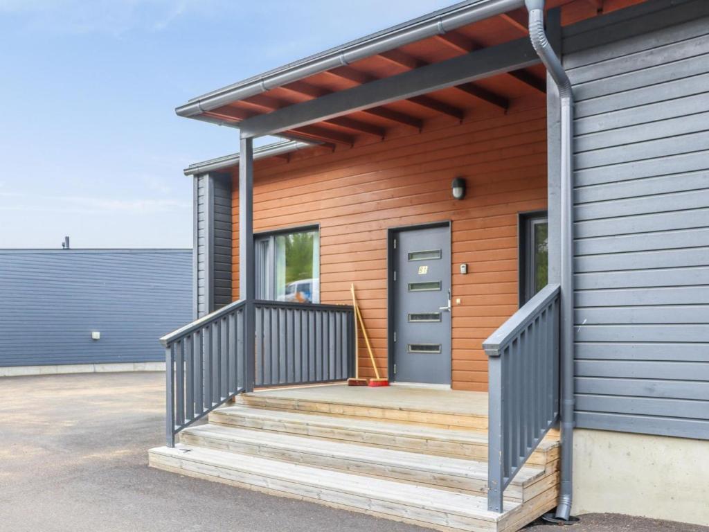 uma casa com um alpendre em madeira com uma porta em Holiday Home Lakevillas b1 price includes 4 ski passe by Interhome em Hyrynsalmi