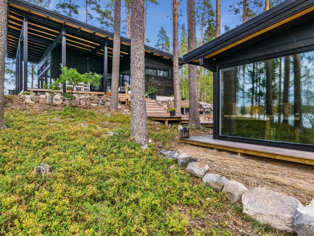 an exterior view of a house with trees at Holiday Home Villa saimaan joutsenlahti by Interhome in Äitsaari