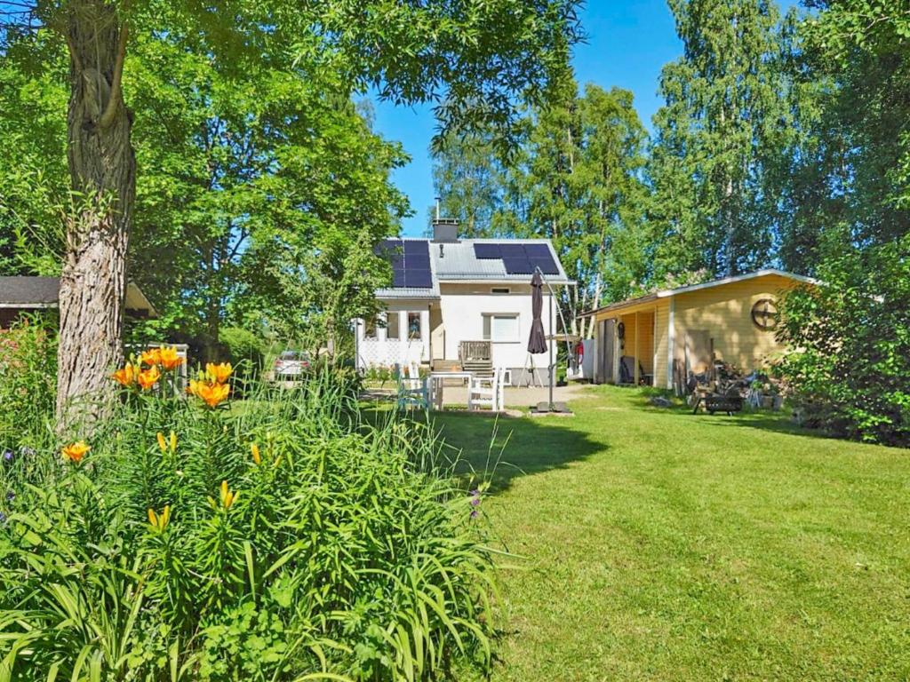 a house with a yard with flowers and a tree at Holiday Home Leponiemi by Interhome in Saarijärvi