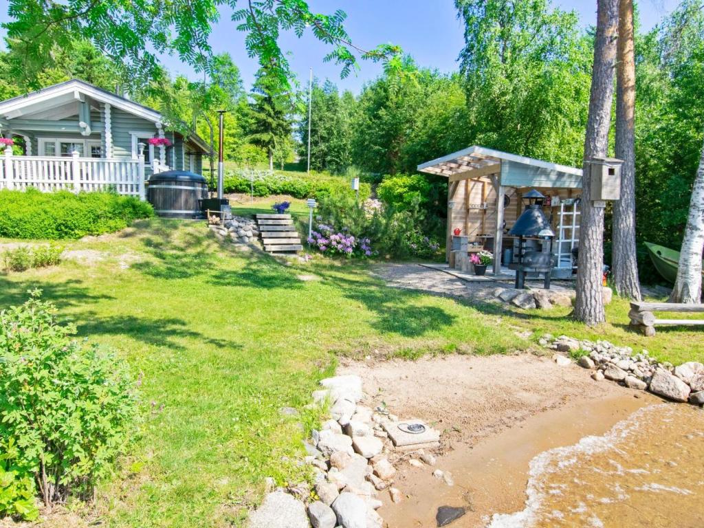 a yard with a house and a house with a pond at Holiday Home Villa kesäranta by Interhome in Muurame