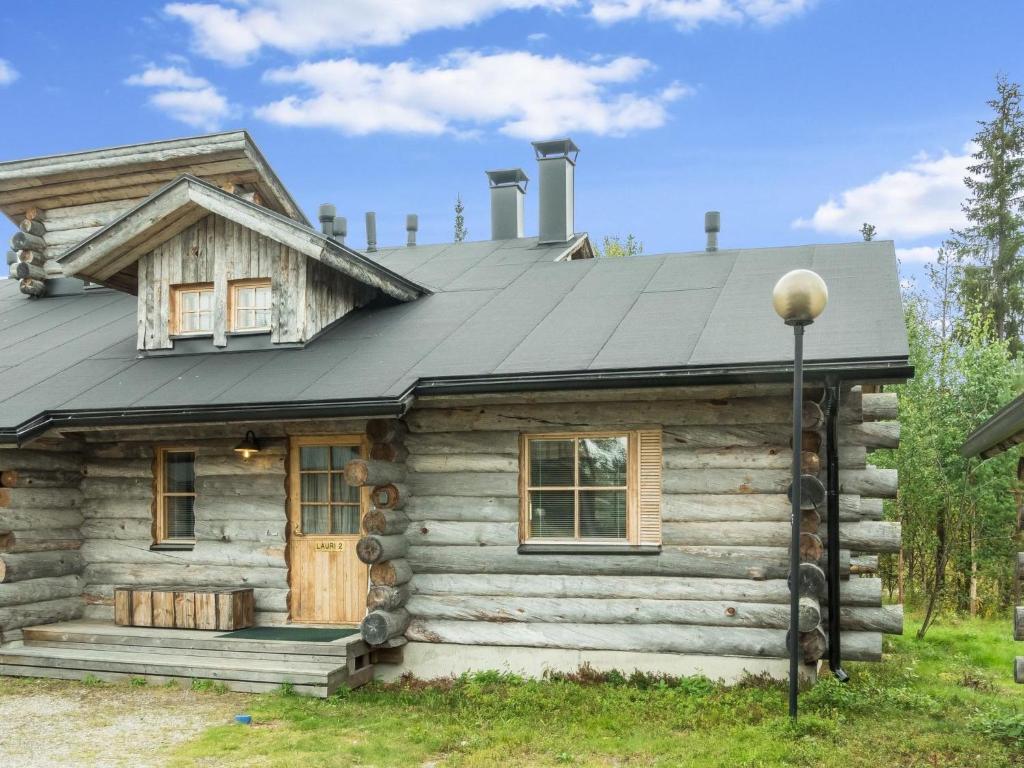 eine Blockhütte mit einem Metalldach und einer Veranda in der Unterkunft Holiday Home Lauri 2 by Interhome in Sirkka