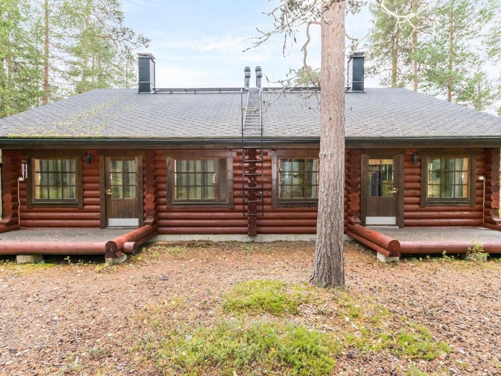 a log cabin with a tree in front of it at Holiday Home Antura b by Interhome in Pyhätunturi