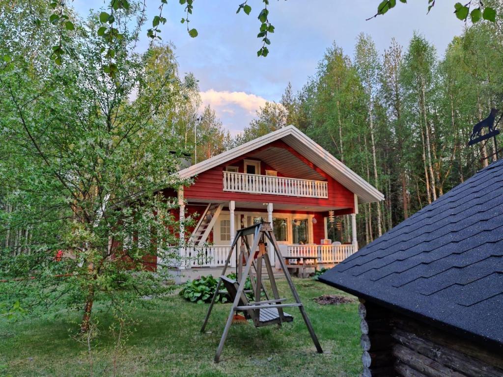 una cabaña de madera con un parque infantil delante de ella en Holiday Home Koivulahden reinola by Interhome, en Raanujärvi
