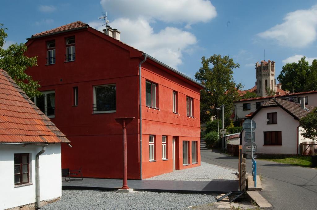 Jetřichovice的住宿－Pension Merano，街道边的红色建筑