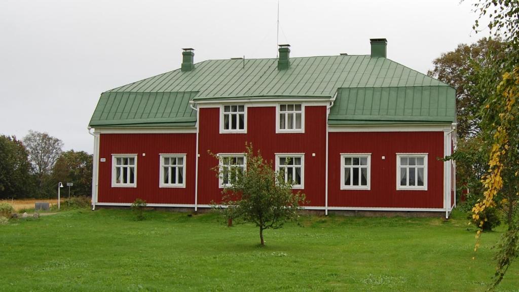 un granero rojo con techo verde en un campo de césped en Övermark Bed & Breakfast, 