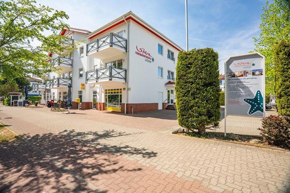 a large white building with a sign in front of it at Stern FeWo Strandstraße in Ostseebad Karlshagen