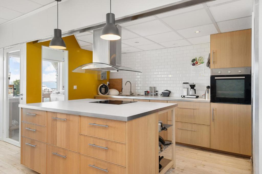 a kitchen with wooden cabinets and a counter top at Brekstad Gjestehus AS in Brekstad