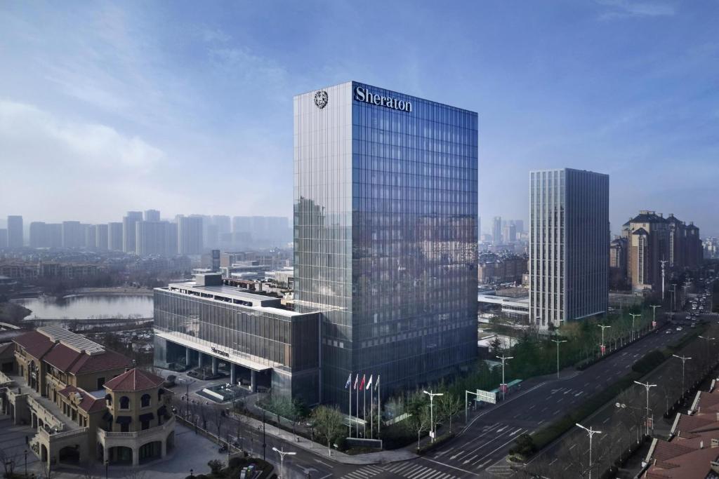 un grand bâtiment avec un panneau sur son côté dans l'établissement Sheraton Qingdao Licang Hotel, à Qingdao
