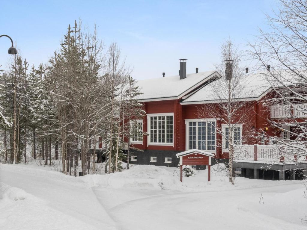 una casa roja con nieve en el suelo en Holiday Home Kätkänlinna a2 by Interhome en Levi