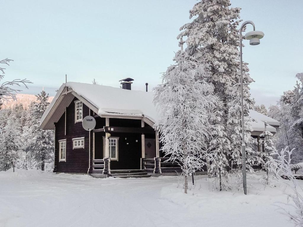 a house covered in snow next to a tree at Holiday Home Sallanrinne b by Interhome in Salla