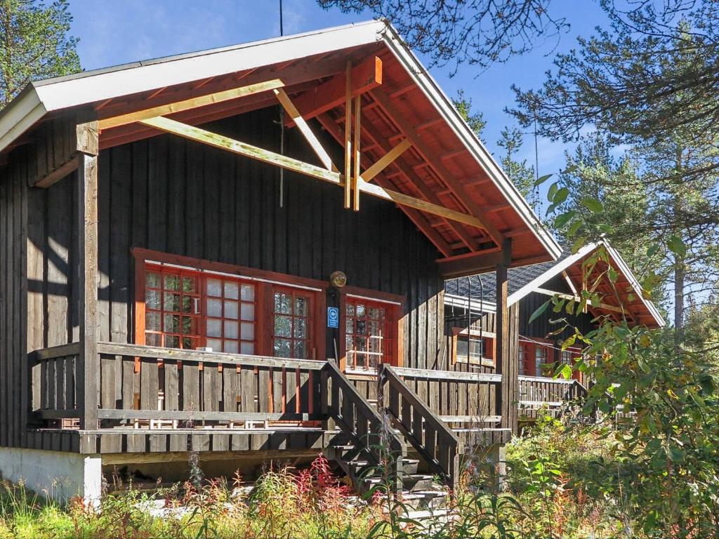 a log cabin with a red door and a porch at Holiday Home Immelkotsa 7 e by Interhome in Levi