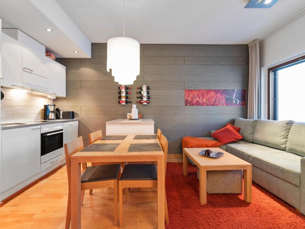 eine Küche und ein Wohnzimmer mit einem Tisch und einem Sofa in der Unterkunft Holiday Home Ski chalet vii 7406 by Interhome in Ylläs
