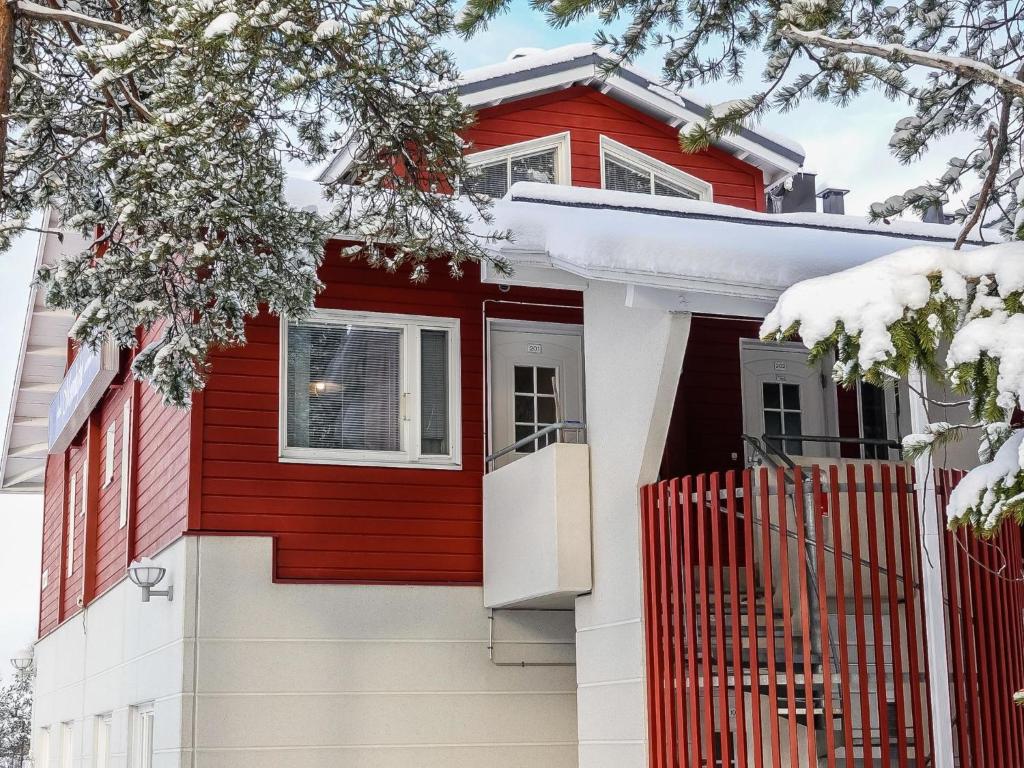 uma casa vermelha e branca com neve em Holiday Home Moonlight 201 by Interhome em Levi