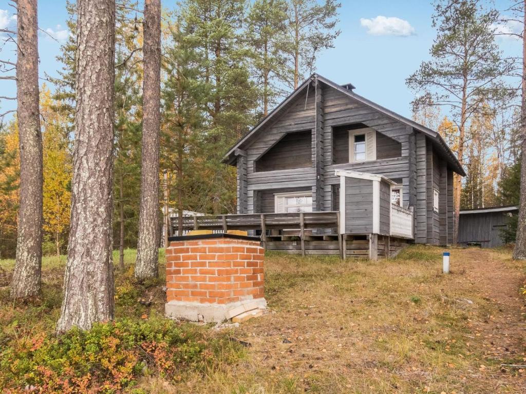 an old house in the woods with a brick chimney at Holiday Home Joulupukin mökki by Interhome in Sonka