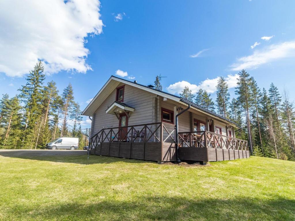 a house on a hill with a van in the background at Holiday Home Aaltola by Interhome in Kokkosenlahti