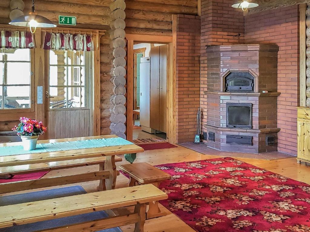 sala de estar con chimenea y mesa de madera en Holiday Home Männikkö by Interhome en Kammola