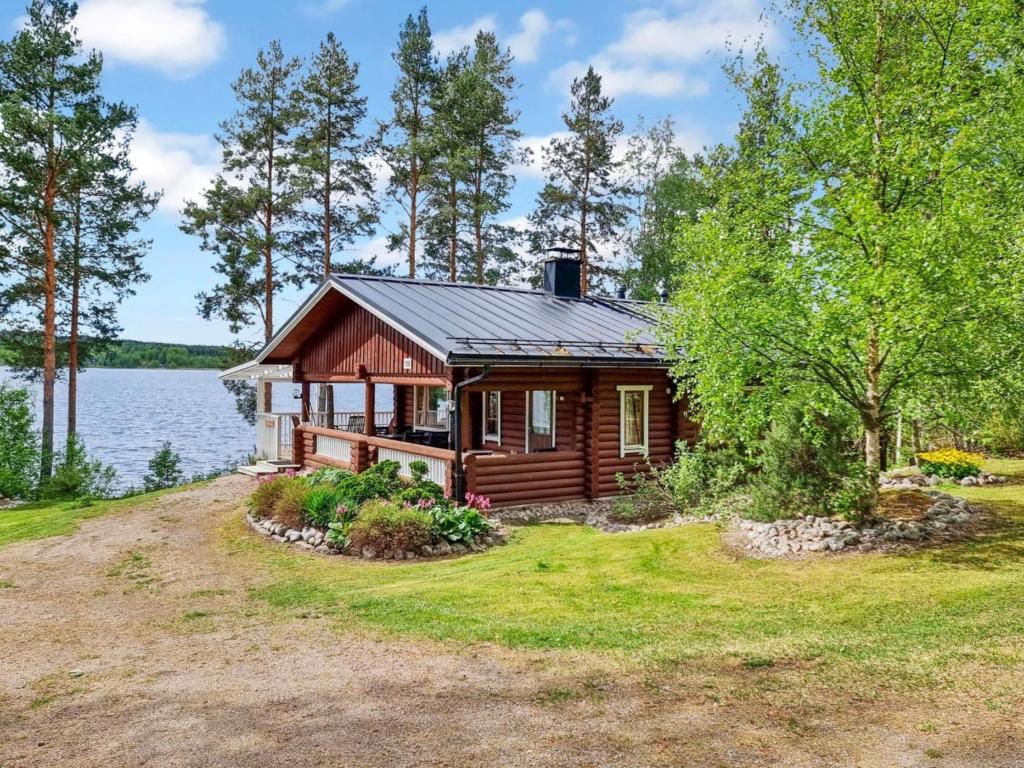 une cabane en rondins sur la rive d'un lac dans l'établissement Holiday Home Saarenranta by Interhome, à Koivisto