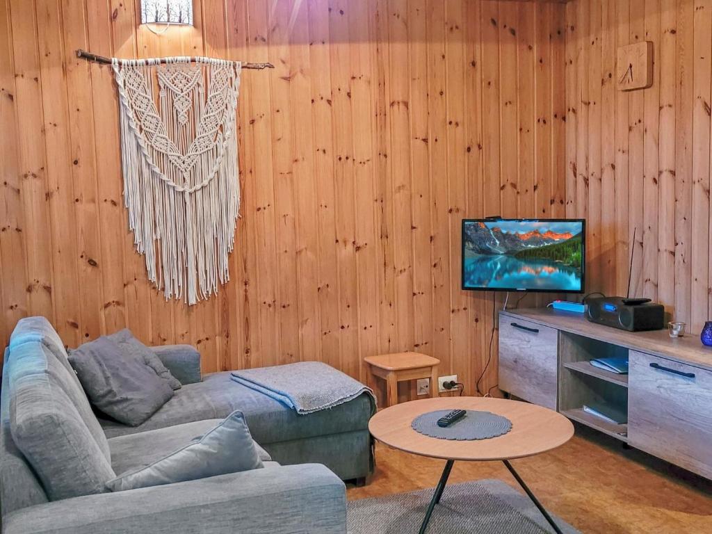 uma sala de estar com um sofá e uma mesa em Holiday Home Ylläskarpalo 3 päätyhuoneisto by Interhome em Äkäslompolo