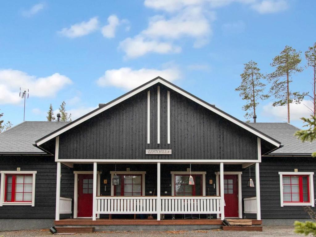 a black house with red doors and red windows at Holiday Home Lehtovilla a by Interhome in Äkäslompolo