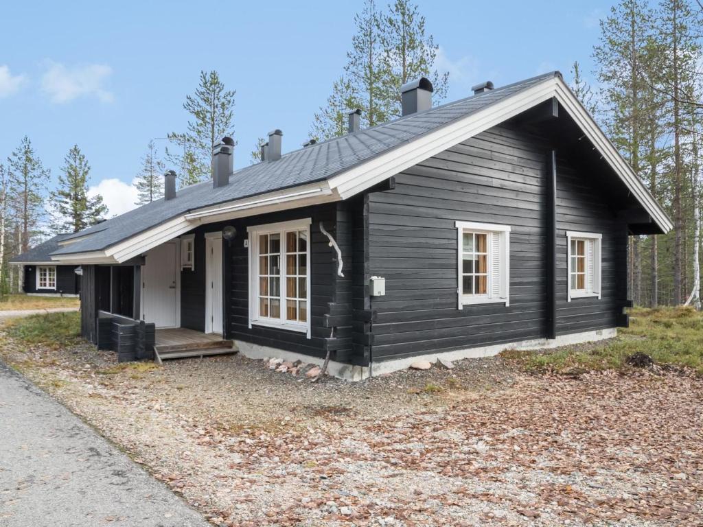 una pequeña casa negra con porche y porche en Holiday Home Lomaylläs h109 -pistopolku 1 a by Interhome en Ylläsjärvi