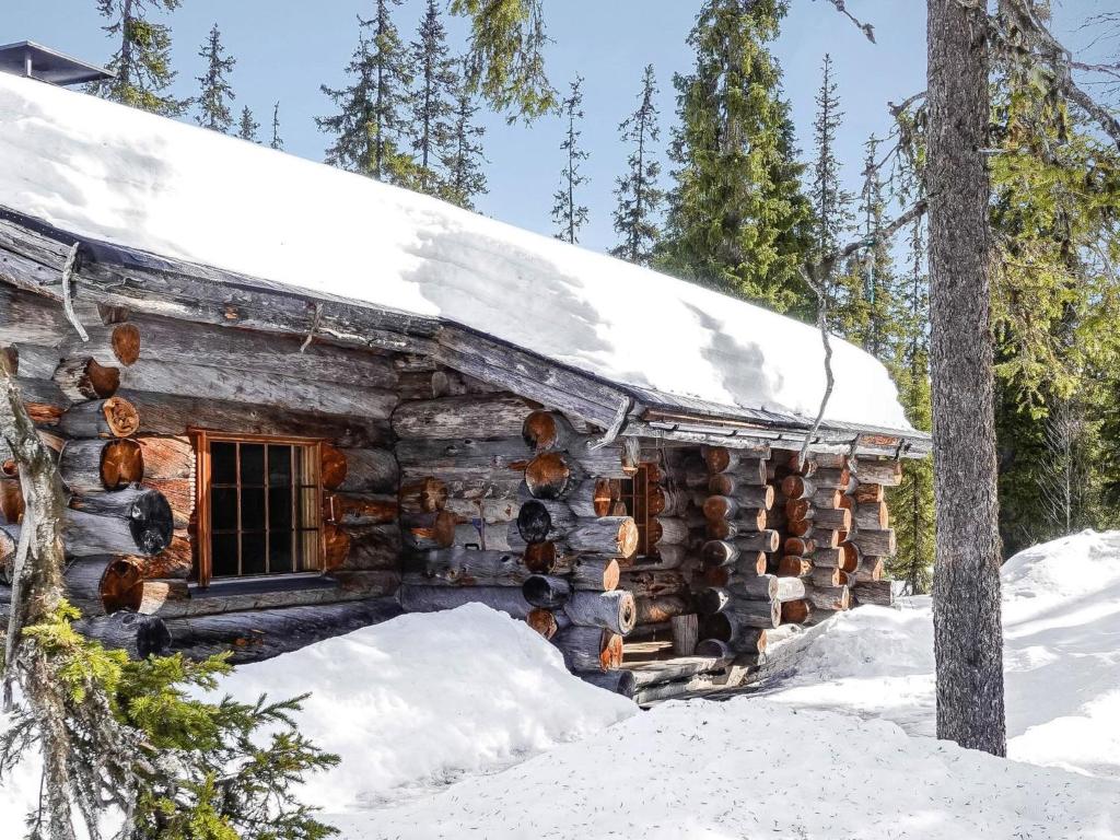 a log cabin with snow on the roof at Holiday Home Luostonseita 3 by Interhome in Luosto