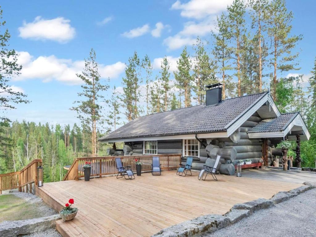 une maison en rondins avec une terrasse et une maison dans l'établissement Holiday Home Juurakkopirtti by Interhome, à Keuruu