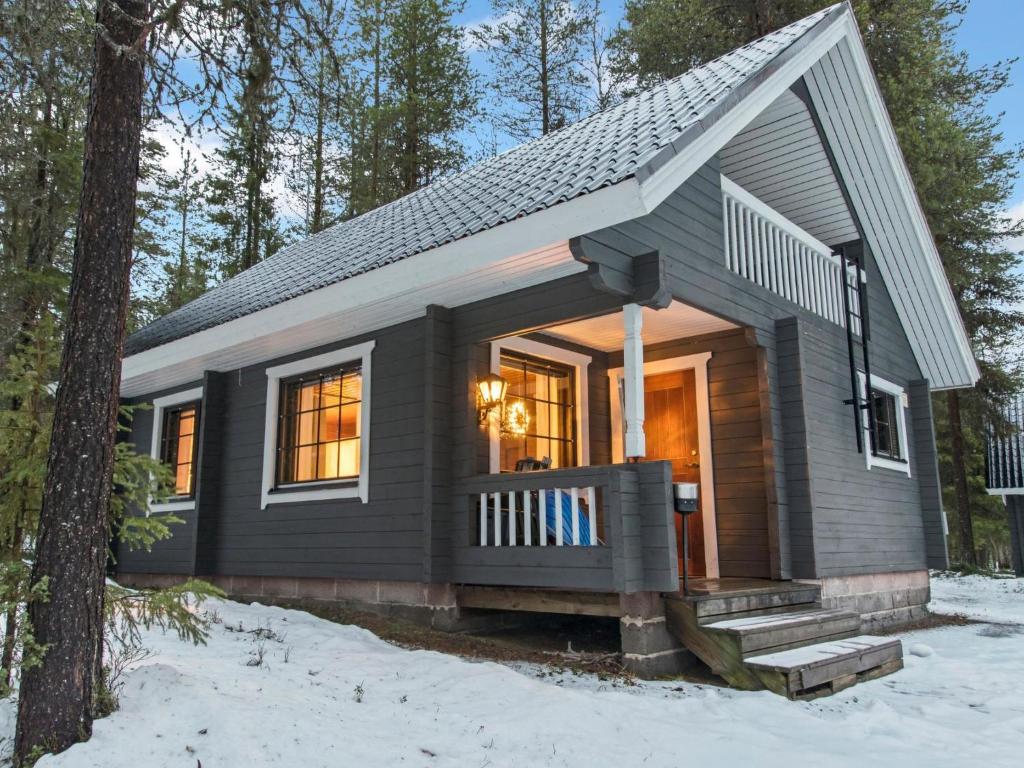 une petite maison avec une terrasse couverte dans la neige dans l'établissement Holiday Home Kaltiotievantie 2 mökki 1 by Interhome, à Ylläsjärvi