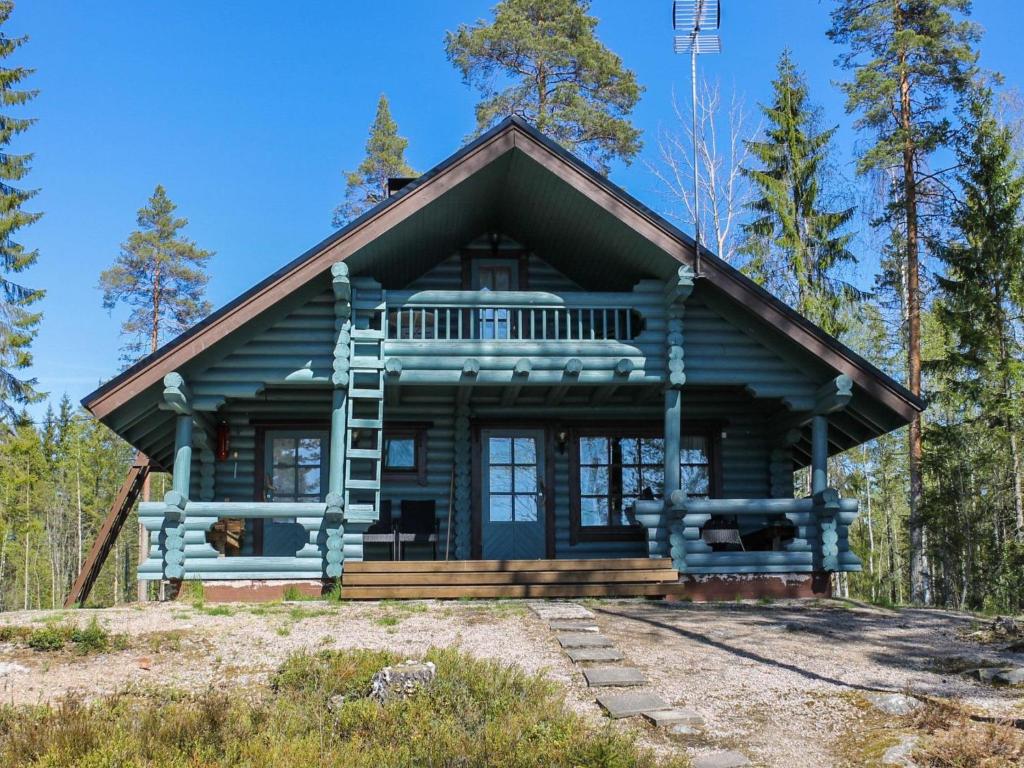 eine Blockhütte im Wald mit einer Veranda in der Unterkunft Holiday Home Marjaranta by Interhome in Konnevesi