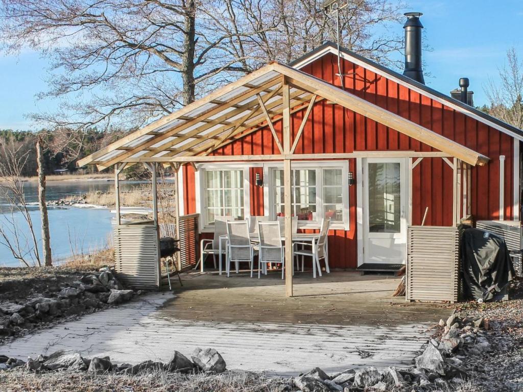uma casa vermelha com uma mesa e cadeiras em Holiday Home Långahuset by Interhome em Västlax