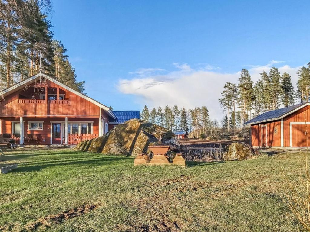 a house with a large rock in the yard at Holiday Home Sanninpirtti by Interhome in Niskamäki